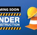Sign saying the web page is under construction with a caution cone and hard hat sitting on top 